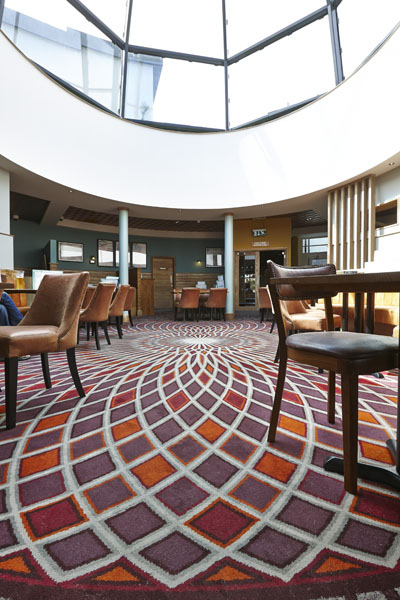 Admiral Collingwood Wetherspoon bespoke carpet with red and orange sharp patterns, designed by Wilton Carpets