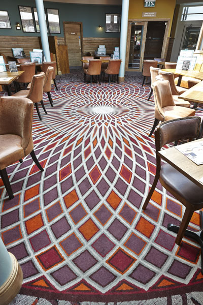 Admiral Collingwood Wetherspoon bespoke carpet with red and orange sharp patterns, designed by Wilton Carpets