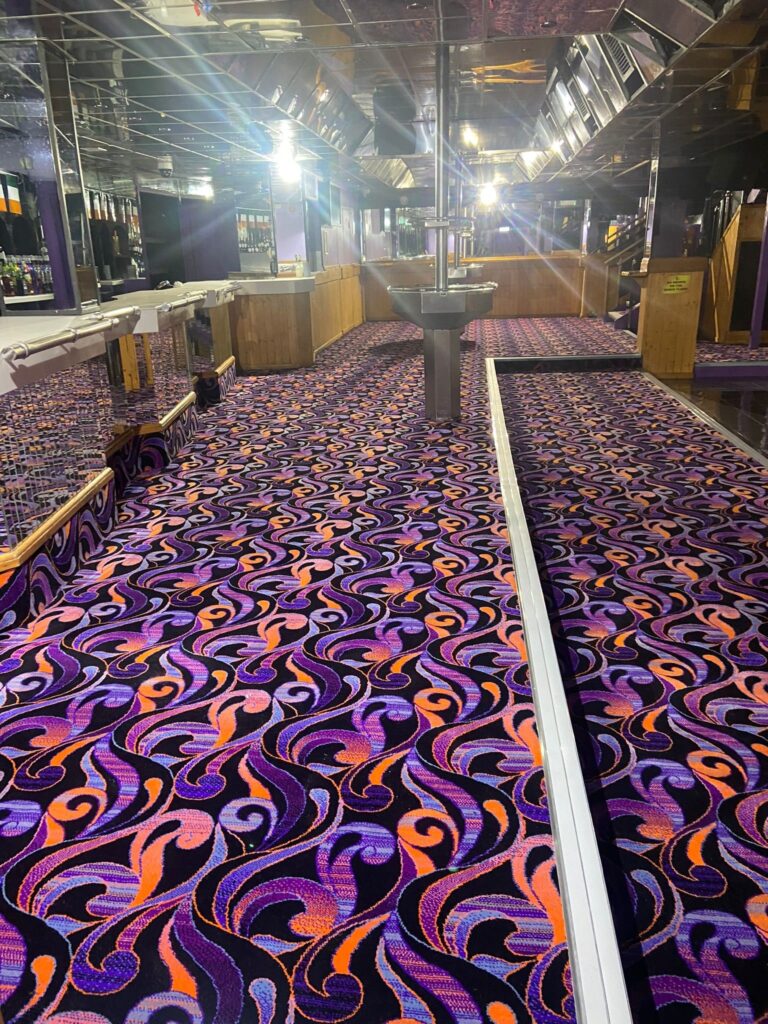Acapulco Nightclub Halifax bar shot lengthways with bespoke purple and black patterned carpets designed by Wilton Carpets