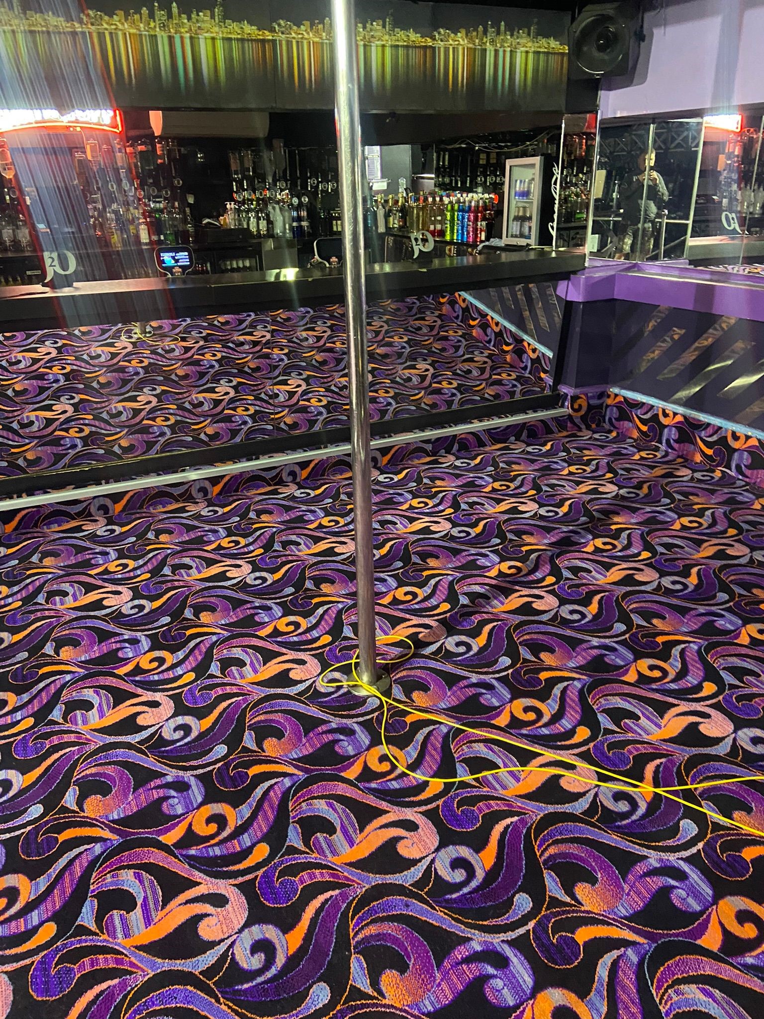 Close up shot of Acapulco Nightclub Halifax pole dancing area with bespoke purple and black patterned carpets designed by Wilton Carpets