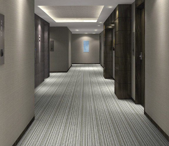 A hotel corridor designed with a stripy black, white and grey carpet