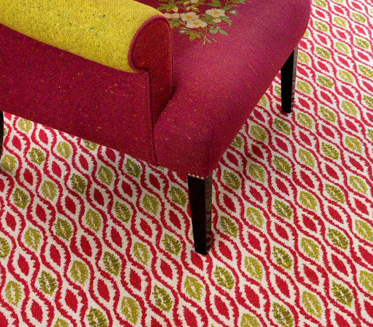 A hotel carpet with red and yellow spherical shapes, and a chair
