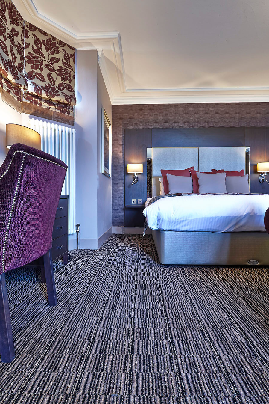 Abbey House Hotel bedroom, with a black, grey and cream striped design carpet, by Wilton Carpets