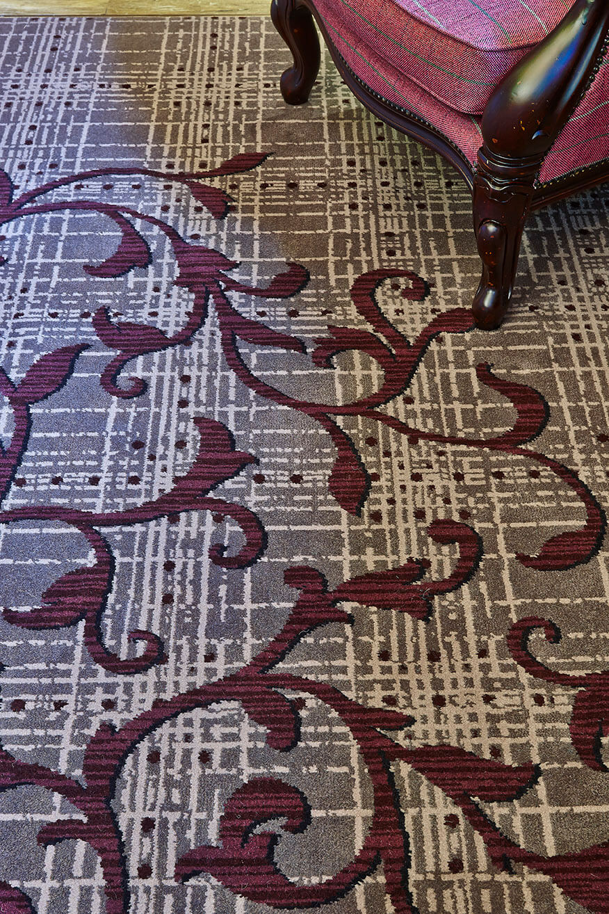 Abbey House Hotel bespoke carpet, with grey and cream strips, as well as red floral patterns, designed by Wilton Carpets